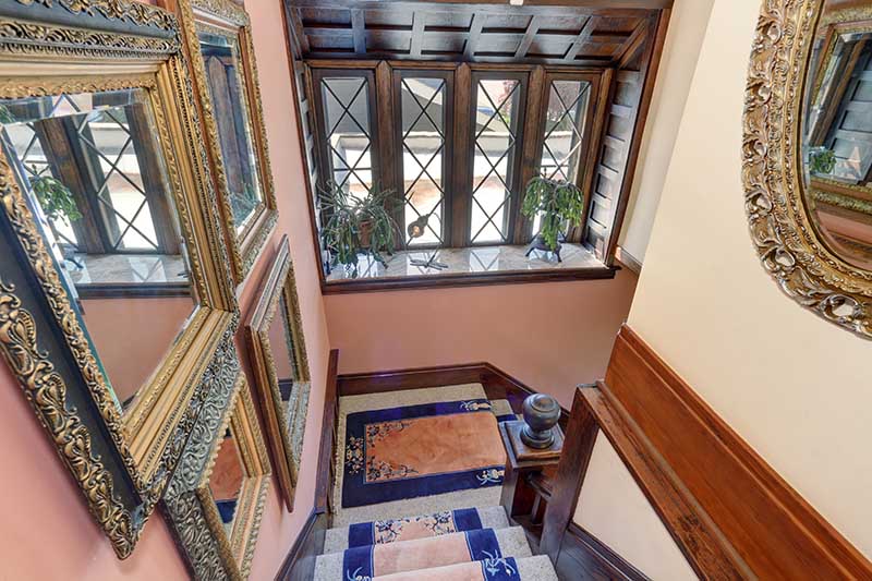 Elegant staircase with royal blue carpets, and decorative mirrors.